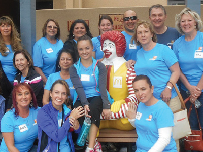 group of volunteers taking group picture with ronald mcdonald statue